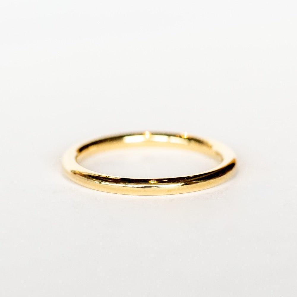 A polished yellow gold wedding band.