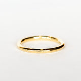 A polished yellow gold wedding band.