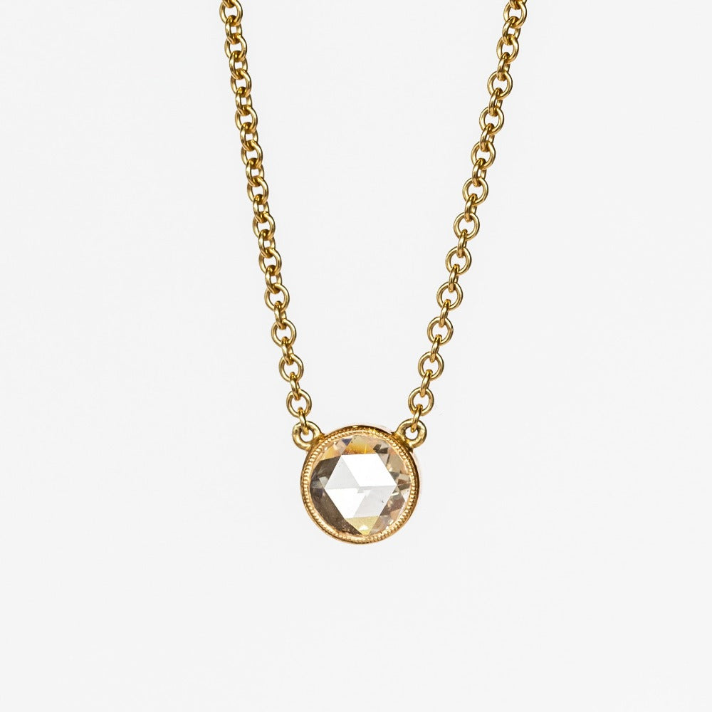 A round rose cut diamond bezel set in a station style necklace with classic gold cable chain.