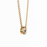 A round rose cut diamond bezel set in a station style necklace with classic gold cable chain.