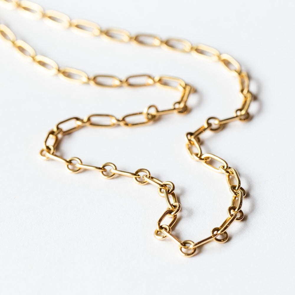 A gold chain necklace made up of alternating round and oval links.