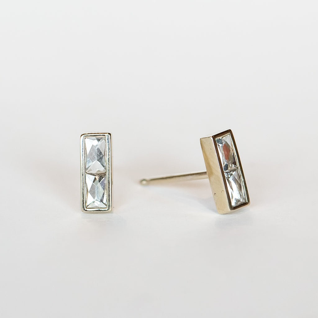 Diamond stud earrings featuring pairs of French cut diamonds bezel set in white gold with a post back.