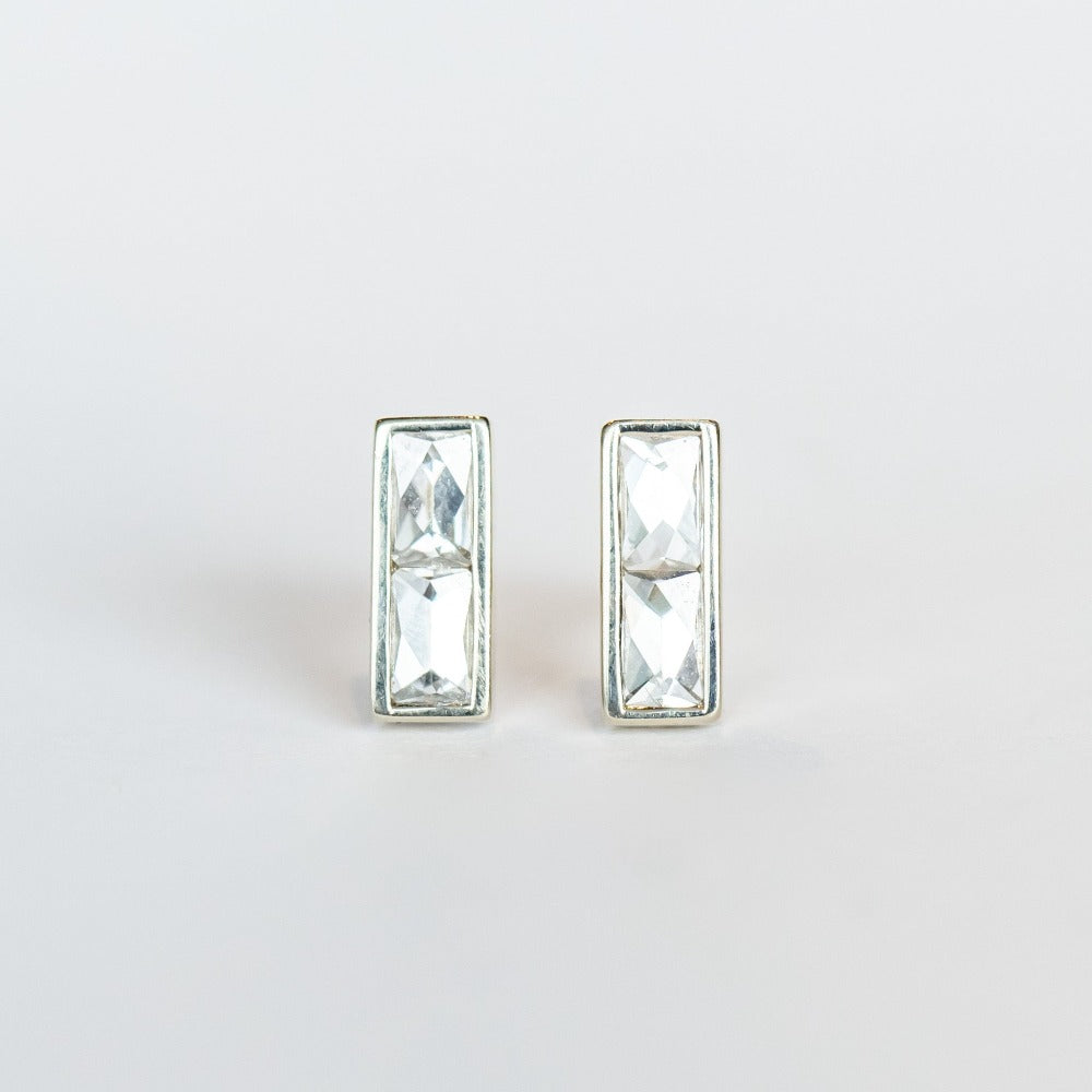 Diamond stud earrings featuring pairs of French cut diamonds bezel set in white gold with a post back.