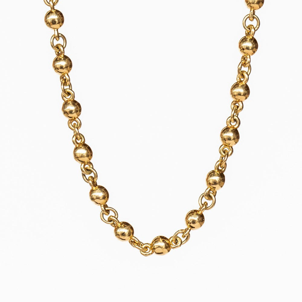 A yellow gold chain necklace made up of spherical links.