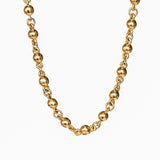 A yellow gold chain necklace made up of spherical links.