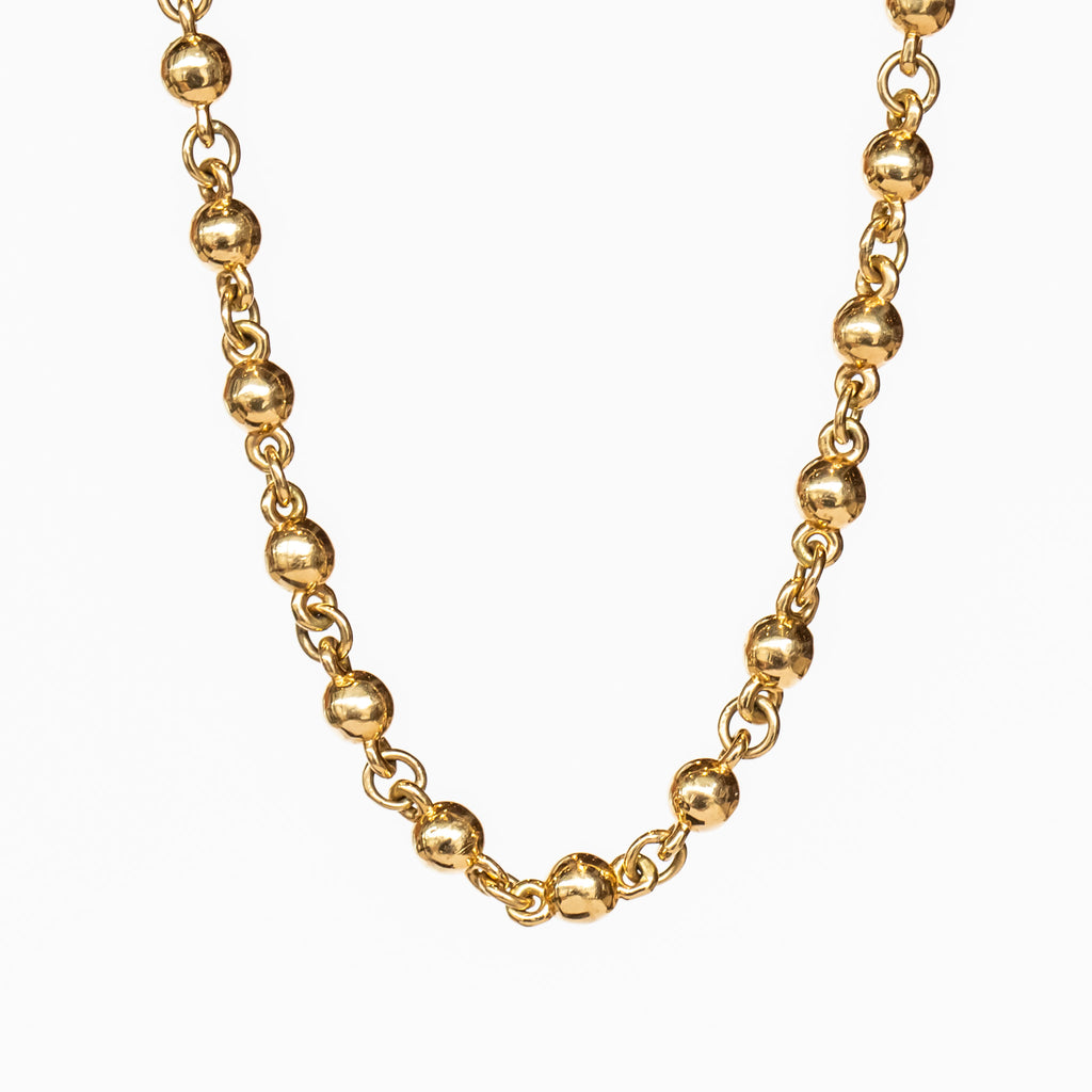 A yellow gold chain necklace made up of spherical links.