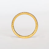 A textured gold wedding band with a row of French pave set diamonds around the top half.