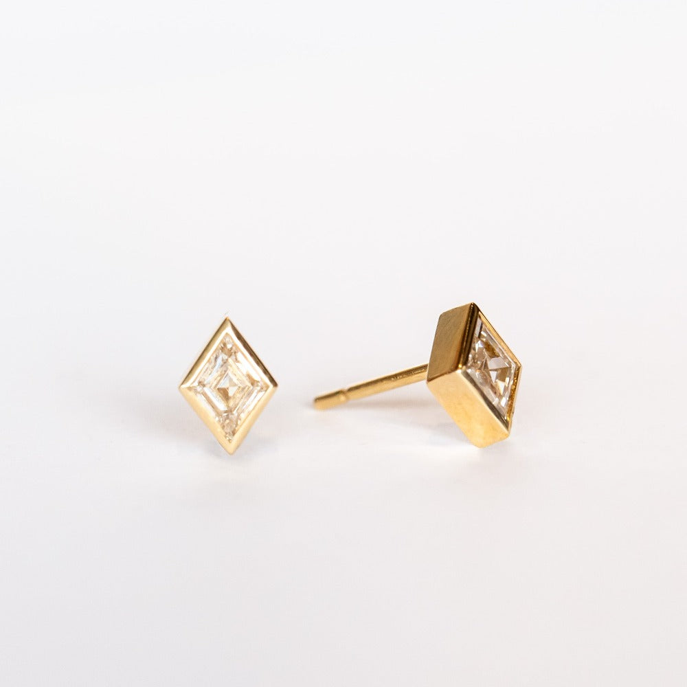 Lozenge (diamond shape) cut diamond stud earrings set in yellow gold bezels with post backs.