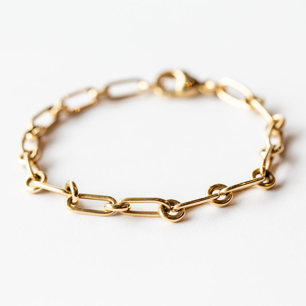 A yellow gold chain bracelet made up of alternating round and elongated oval links.