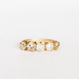 A yellow gold wedding band featuring five mixed-cut diamonds prong set with leaf-like accents on each side.