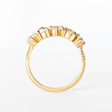 A yellow gold wedding band featuring five mixed-cut diamonds prong set with leaf-like accents on each side.