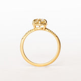 A yellow gold solitaire diamond engagement ring featuring a prong set old european cut diamond and a slender matte finish, leaf accented band.