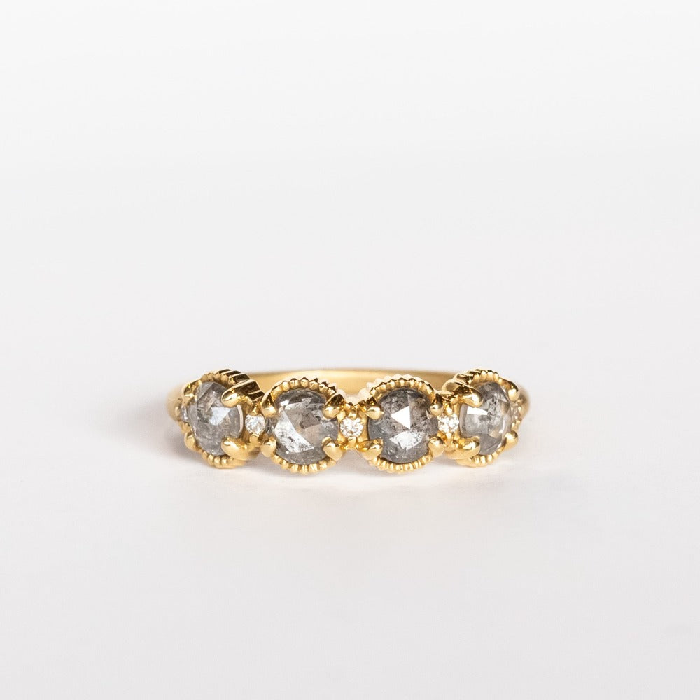 Four rose cut salt and pepper diamonds are set into a yellow gold band with beaded edge details.