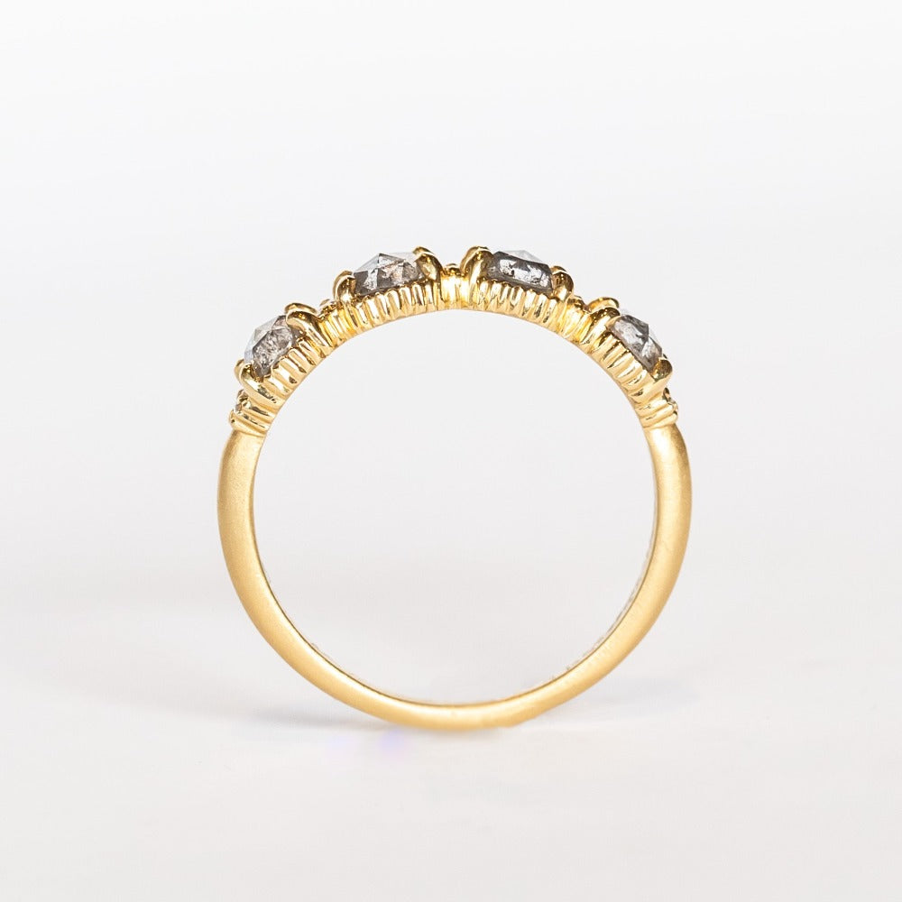 Four rose cut salt and pepper diamonds are set into a yellow gold band with beaded edge details.
