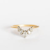 A diamond contour ring crafted with a slim yellow gold band. Three marquise diamonds are bezel set into white gold with a curved outline and delicate leaf details.