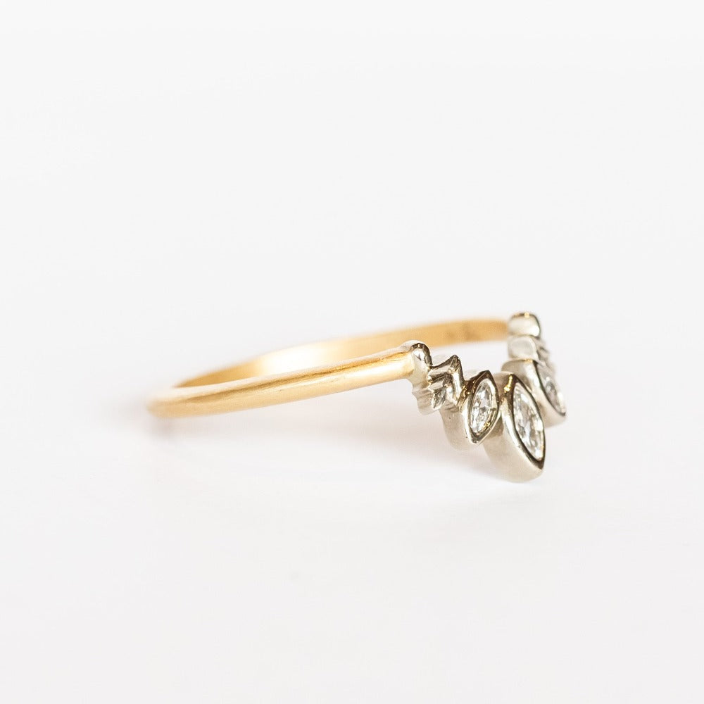 A diamond contour ring crafted with a slim yellow gold band. Three marquise diamonds are bezel set into white gold with a curved outline and delicate leaf details.