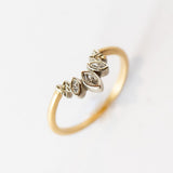 A diamond contour ring crafted with a slim yellow gold band. Three marquise diamonds are bezel set into white gold with a curved outline and delicate leaf details.