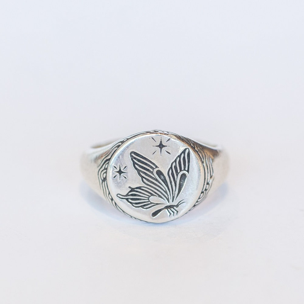 Sterling silver signet ring featuring an engraved butterfly and twinkling stars.