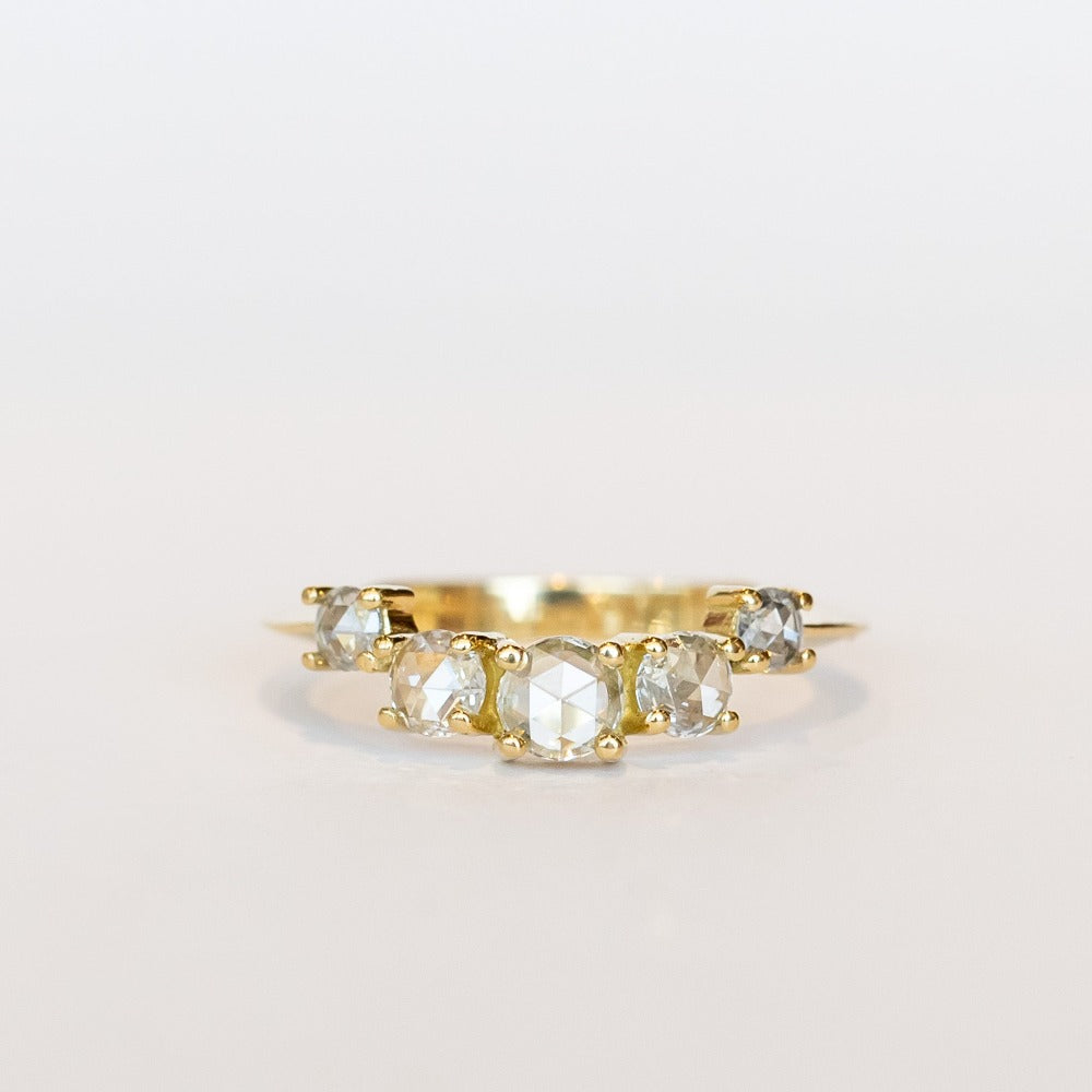 A diamond contour wedding band featuring five graduated size rose cut diamonds set in 18 karat yellow gold.
