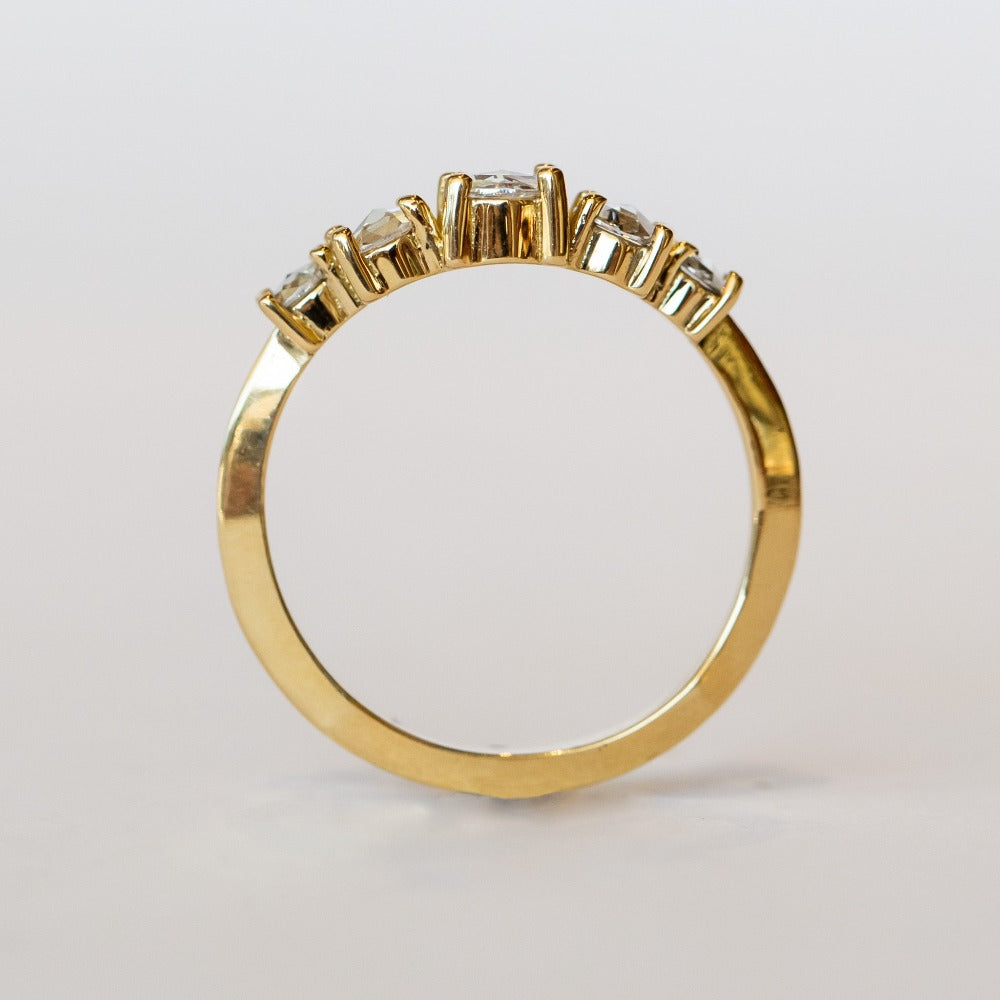 A diamond contour wedding band featuring five graduated size rose cut diamonds set in 18 karat yellow gold.