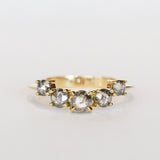 A curved diamond contour band crafted in 18 karat yellow gold, set with five graduated size, rose cut, salt and pepper diamonds.