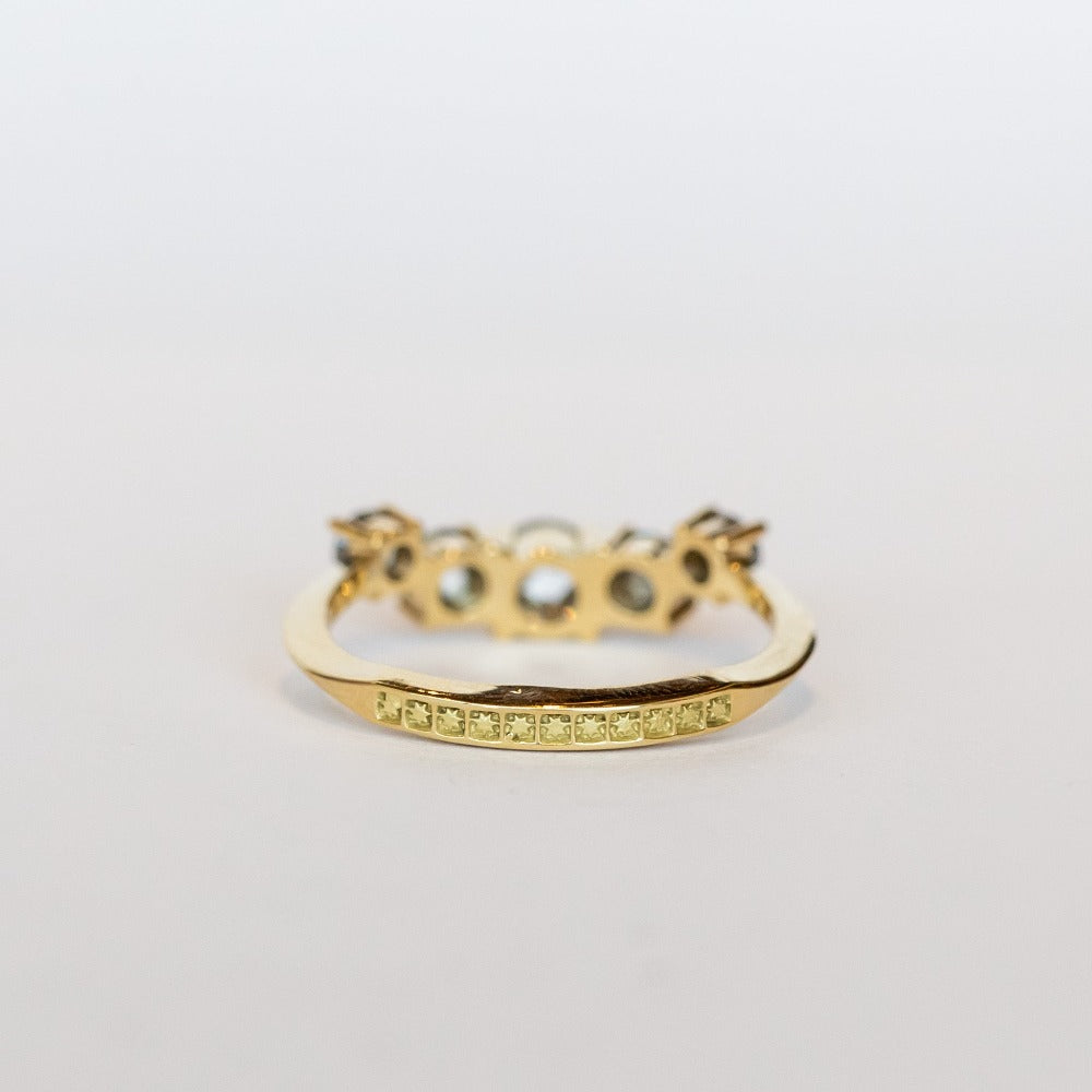A curved diamond contour band crafted in 18 karat yellow gold, set with five graduated size, rose cut, salt and pepper diamonds.