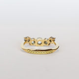 A curved diamond contour band crafted in 18 karat yellow gold, set with five graduated size, rose cut, salt and pepper diamonds.