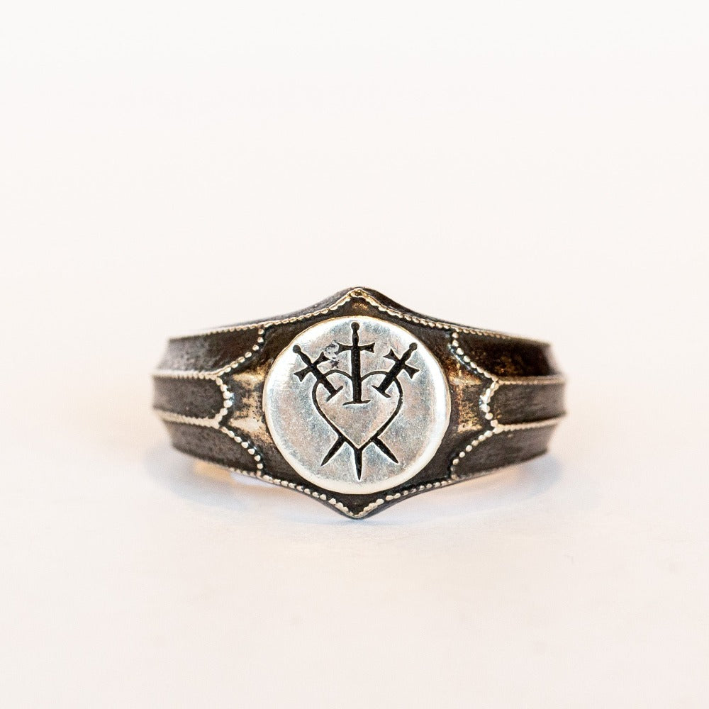 Petite blackened silver signet ring featuring a three of swords engraving on its face.