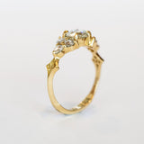 A diamond engagement ring that features a 1 carat rose cut center stone flanked by six rose cut side stones, in a polished 18k yellow gold setting.