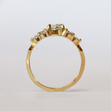 A diamond engagement ring that features a 1 carat rose cut center stone flanked by six rose cut side stones, in a polished 18k yellow gold setting.