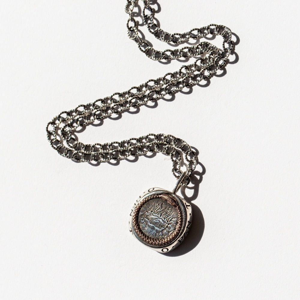 engraved silver and rose gold pendant of ouroboros.