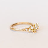 A tapering cluster of antique cut white diamonds all nestled amongst polished granules of rich yellow gold on a textured band.
