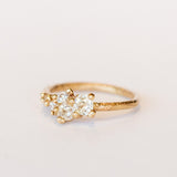 A tapering cluster of antique cut white diamonds all nestled amongst polished granules of rich yellow gold on a textured band.