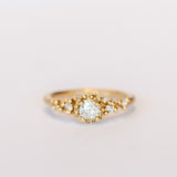 Unique antique cut diamond engagement ring with golden granules, on a gently textured band.