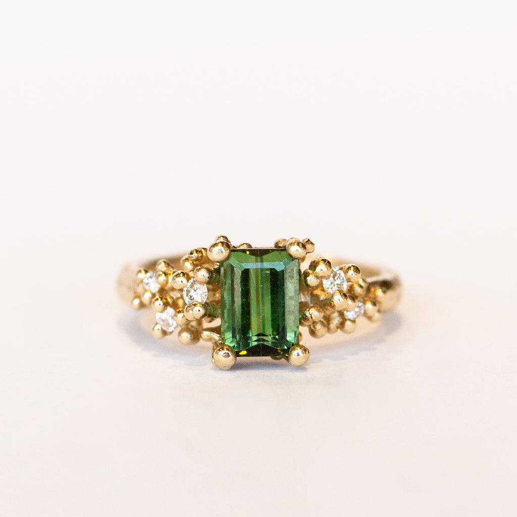 A beautiful deep green tourmaline&nbsp;ring with white&nbsp;diamonds and granules of yellow gold, on a lightly textured band.