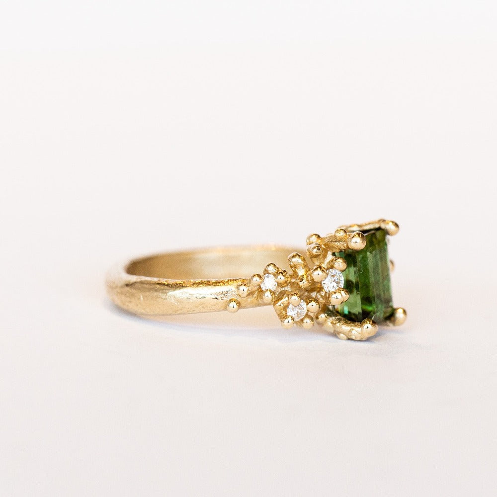 A beautiful deep green tourmaline&nbsp;ring with white&nbsp;diamonds and granules of yellow gold, on a lightly textured band.