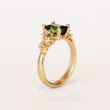 A beautiful deep green tourmaline&nbsp;ring with white&nbsp;diamonds and granules of yellow gold, on a lightly textured band.