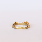 A stackable band featuring five white diamonds nestling amongst granules of yellow gold on a gently textured half round band.