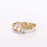 An asymmetrical gold cluster ring set with a variety of pastel gemstones amongst gold granules.