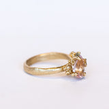 An asymmetrical gold cluster ring set with a variety of pastel gemstones amongst gold granules.