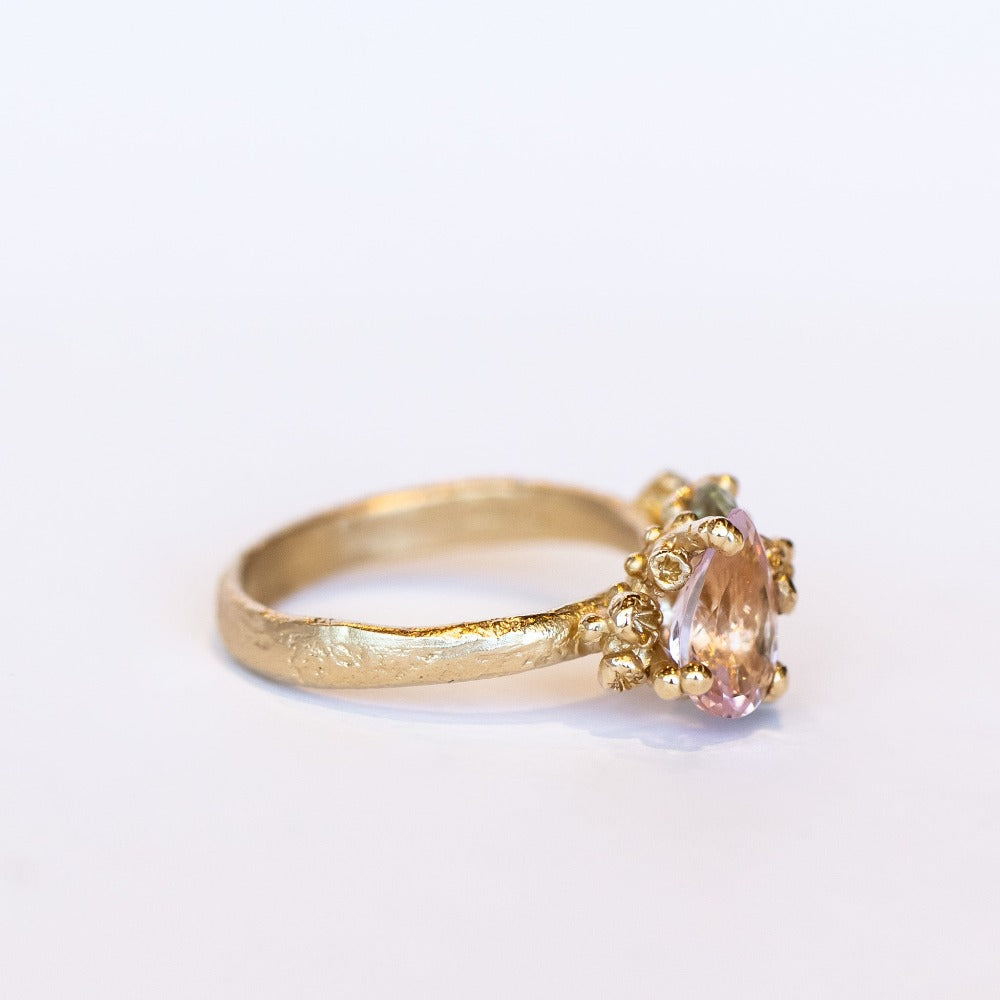 An asymmetrical gold cluster ring set with a variety of pastel gemstones amongst gold granules.