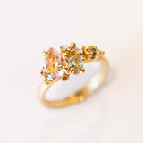 An asymmetrical gold cluster ring set with a variety of pastel gemstones amongst gold granules.