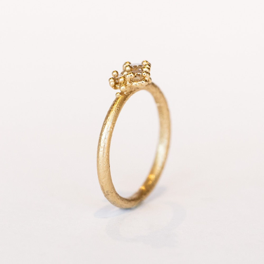 A dainty yellow gold and diamond cluster ring.