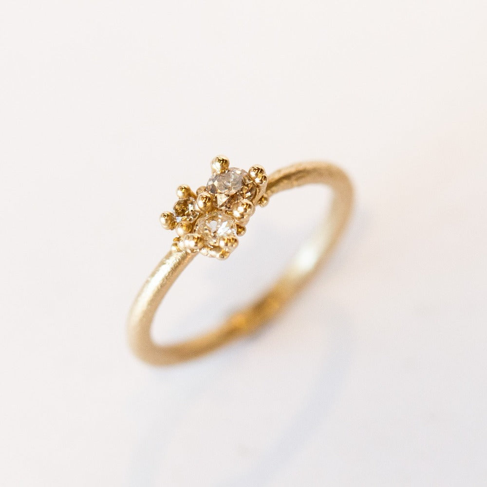 A dainty yellow gold and diamond cluster ring.