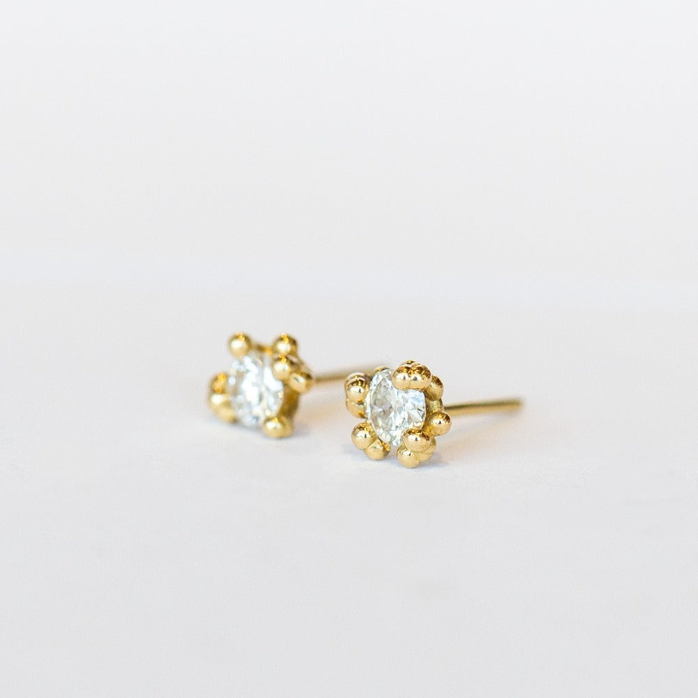 Unique solitaire diamond stud earrings with golden granules in yellow gold.