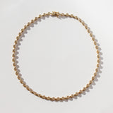 A diamond tennis necklace made up of hexagonal links each set with a small round diamond.
