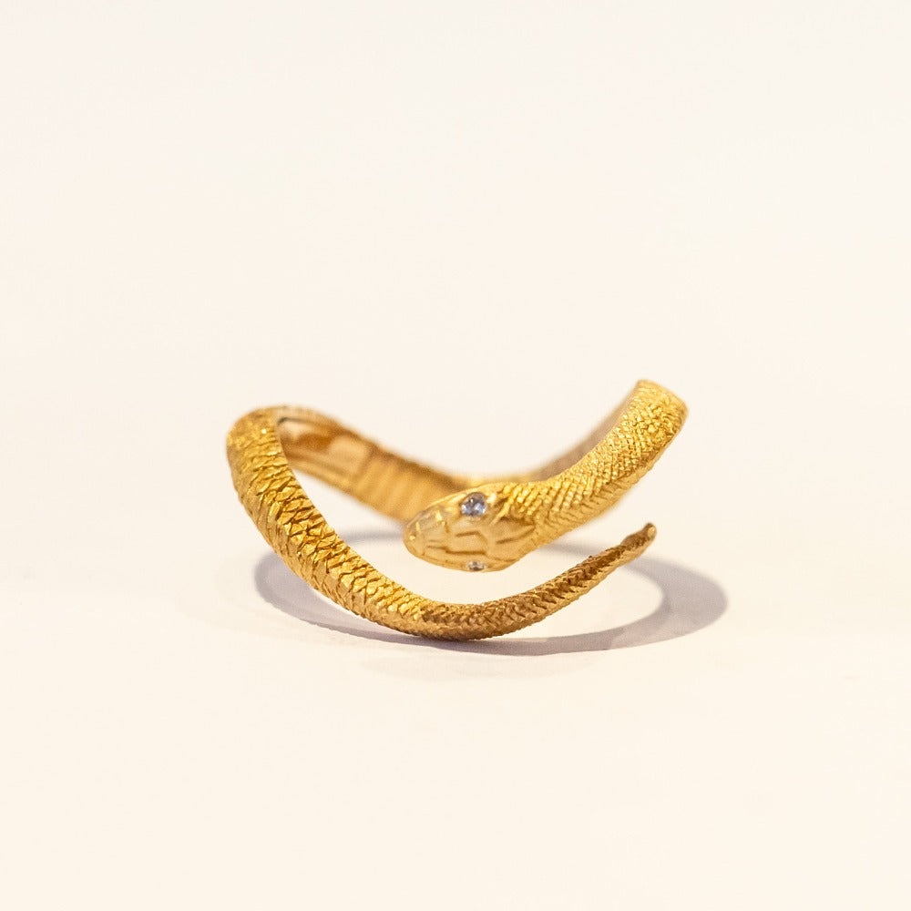 An intricately carved serpent ring that features scales and diamond eyes.