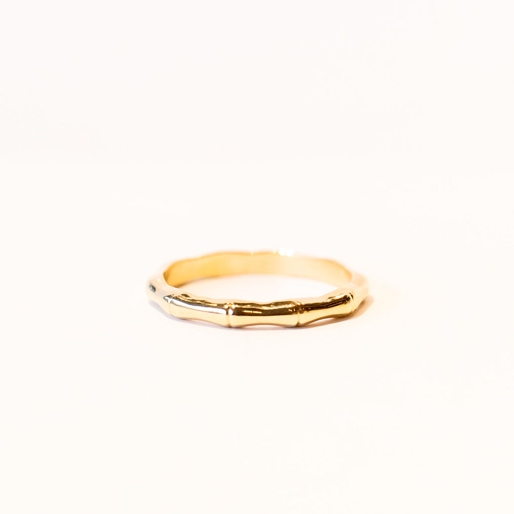 A yellow gold band carved into bamboo design encircling the finger.