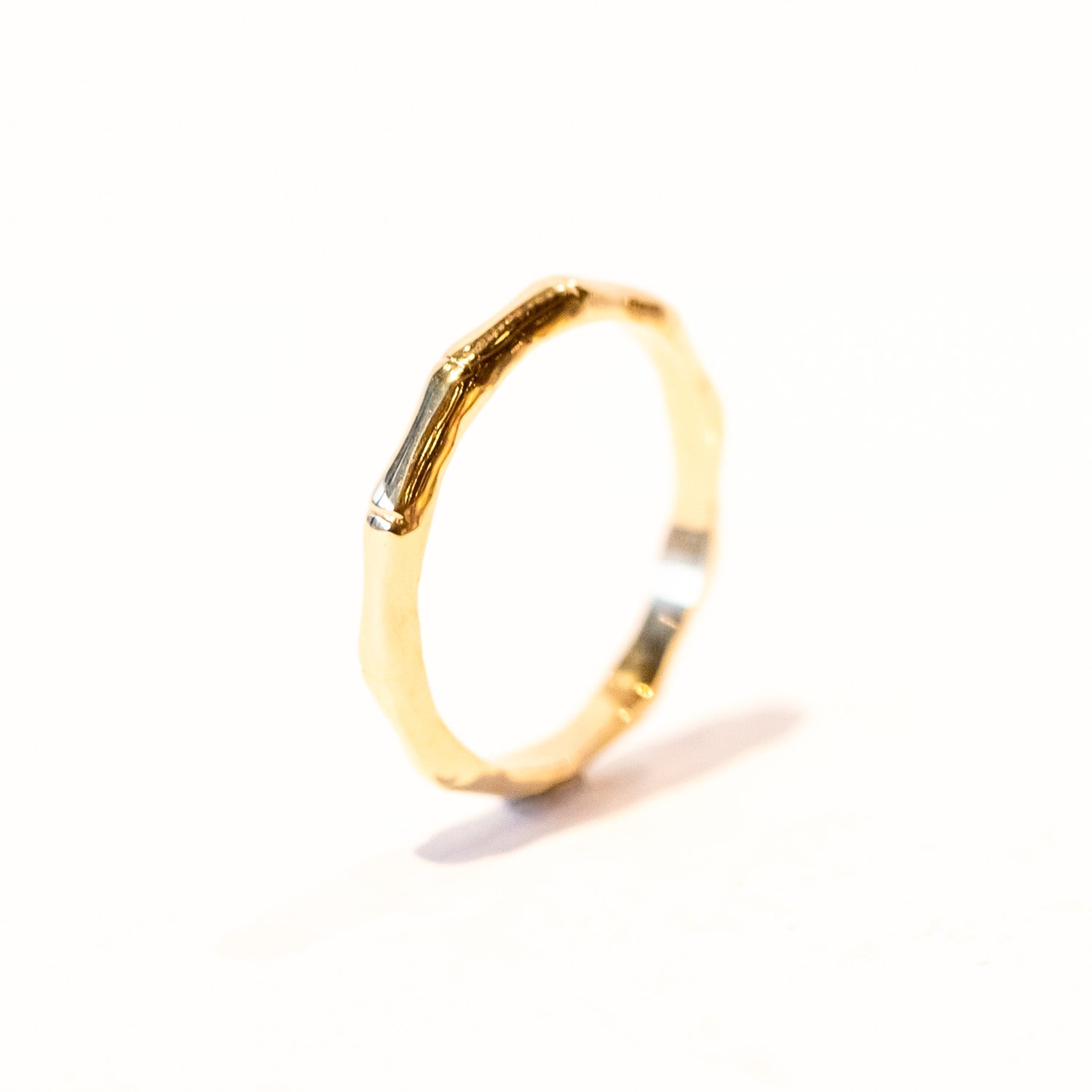 A yellow gold band carved into bamboo design encircling the finger.