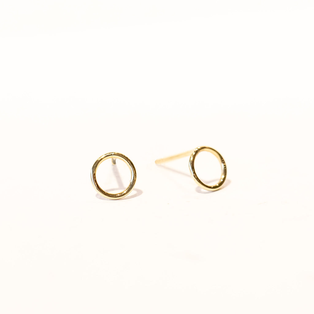 Gold stud earrings made of an open circle of wire.